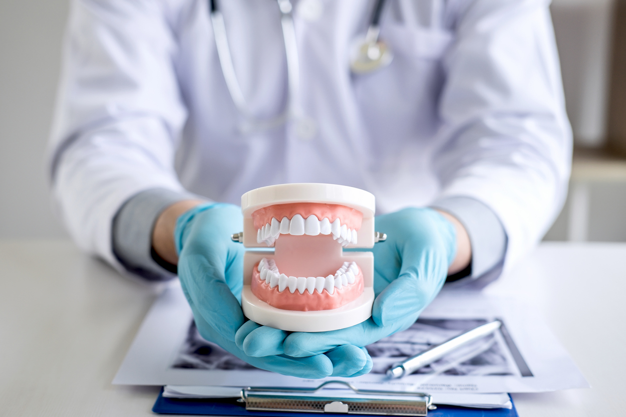 Male doctor or dentist working with patient tooth x-ray film, model and equipment used in the treatment and analysis teeth disease of dental and dentistry at workplace