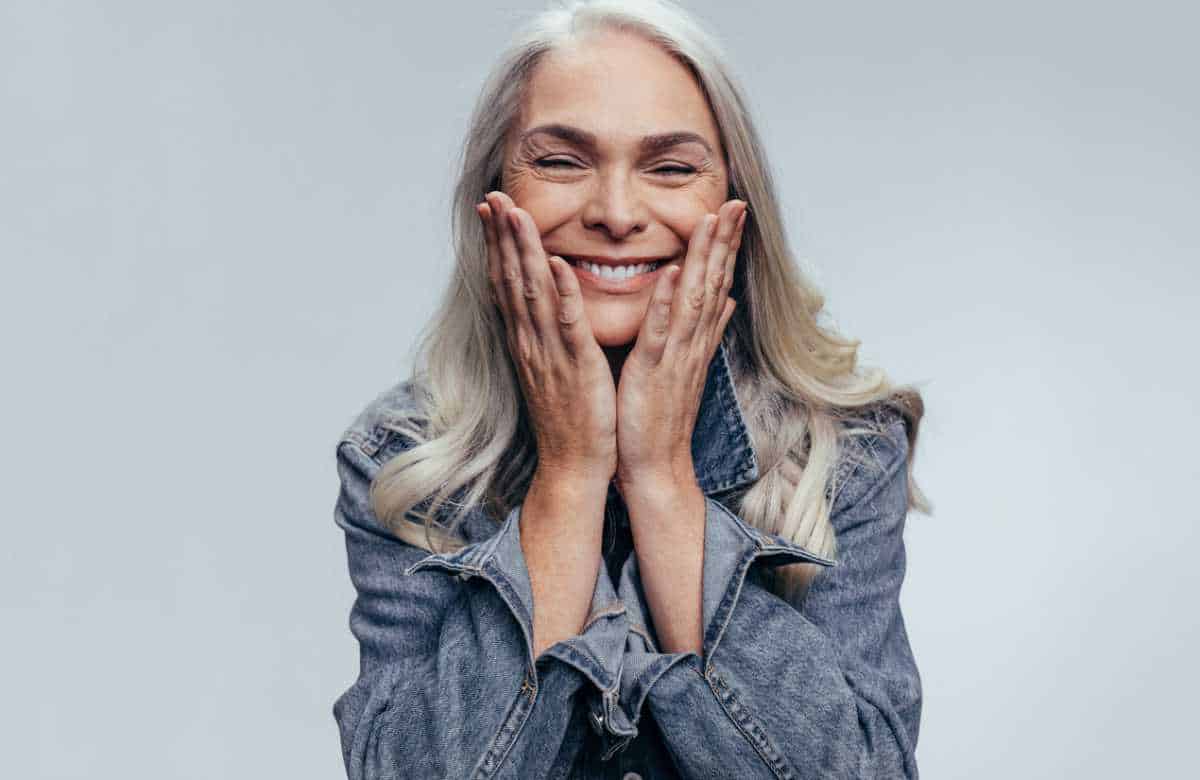woman smiling with hands against cheeks